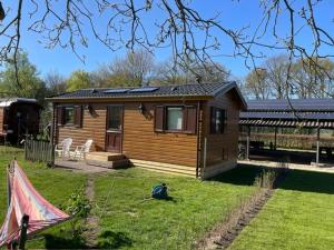 a small wooden cabin in a yard with a yard at De oude stal in Sleen