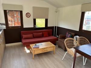 a living room with a red couch and a table at De oude stal in Sleen +16 photos