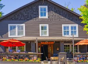 a house with tables and umbrellas in front of it at Hellbender Bed & Beverage in Blowing Rock