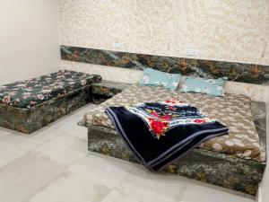 two beds in a room with a blanket on them at Radharani Sewa Sadan in Vrindāvan