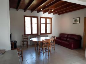 a living room with a table and chairs and a couch at Gîte Du Mas De La Font in Meyrueis