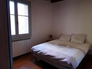 a white bed in a room with a window at Gîte Du Mas De La Font in Meyrueis