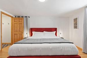 a bedroom with a large white bed with a red headboard at Elegant Manhattan Duplex in Manhattan