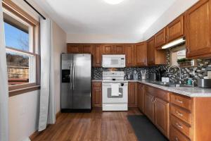 a kitchen with wooden cabinets and a stainless steel refrigerator at Elegant Manhattan Duplex in Manhattan