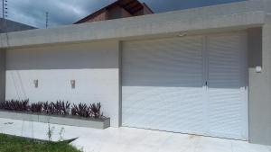 a garage door of a house with plants at Casa com 3 dormitórios na Praia do Preá com Piscina in Prea