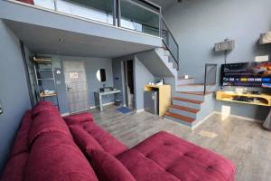 a living room with a large red couch and stairs at Beachside Hotel H8 in Ban Nong Si Tong