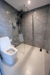 a bathroom with a toilet and a glass shower stall at Beachside Hotel H8 in Ban Nong Si Tong