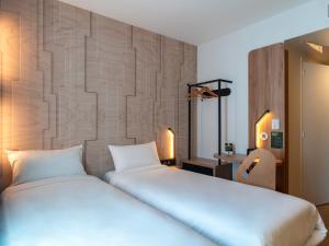 a bedroom with two beds and a wall at B&B HOTEL Concarneau Keriolet in Concarneau