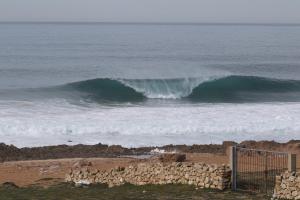 a large wave in the ocean on a beach at Ait Mouli Agdal Retreat in Douar Debra