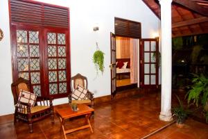 a living room with chairs and a table and a room at Hamilton View in Negombo