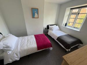 a bedroom with two beds and a window at Pelican House in Bridport