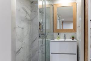 a bathroom with a shower and a sink and a mirror at Les Petits Volets Appartements à 100m de la mer in Antibes +33 photos