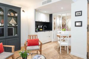 a kitchen and living room with a table and chairs at Les Petits Volets Appartements à 100m de la mer in Antibes