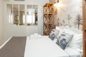a bedroom with a white bed with two pillows at Les Petits Volets Appartements à 100m de la mer in Antibes