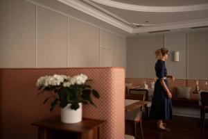 a woman standing in a dining room at Vitalpina Hotel Schulerhof in Plaus