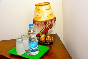 a lamp on a table with a bottle of water at Hamilton View in Negombo +8 photos