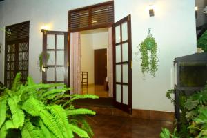 an open door of a house with green plants at Hamilton View in Negombo