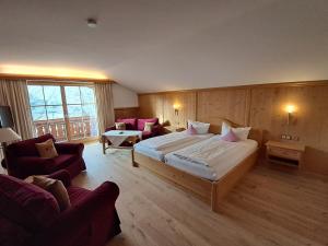 a hotel room with a large bed and a couch at Hotel Seerose in Rottach-Egern