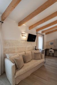 a living room with a couch and a flat screen tv at Sa Pobla Rooms Ex Flor de Mandarina in Sa Pobla
