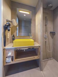 a bathroom with a yellow sink and a shower at HIAMO Hotel Hamburg-Bergedorf in Hamburg +25 photos