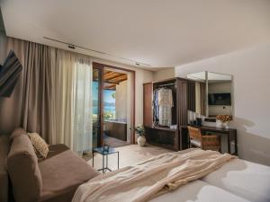a bedroom with a bed and a couch and a mirror at Perla Del Mare in Alikanas