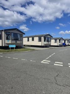 a row of mobile homes on the side of a road at Barmouth wave - Sunnysands Holiday Park caravan in Llanddwywe