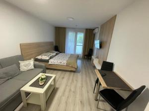a living room with a couch and a bed at Apartmán Flower in Podhájska +2 photos