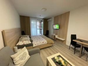 a bedroom with a bed and a living room at Apartmán Flower in Podhájska