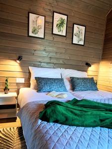 a bedroom with a bed with a book on it at Euforia Górzno - nowoczesne domki nad jeziorem z sauną, balią, jacuzzi in Górzno