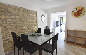 a dining room with a stone wall and a table and chairs at Comfortable vacation retreat with parking in Plovanija