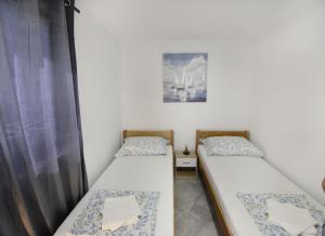 two twin beds in a room with a window at Comfortable vacation retreat with parking in Plovanija