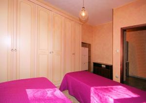 1 Schlafzimmer mit 2 Betten und rosa Bettwäsche in der Unterkunft Aria Di Mare in Borghetto Santo Spirito