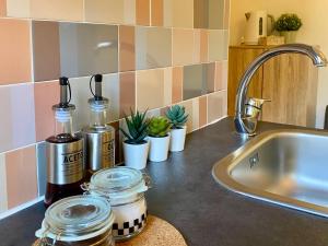 a kitchen counter with jars and plants and a sink at Tao House in Taormina