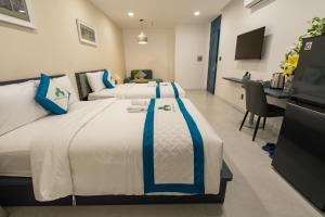 a hotel room with two beds and a desk at Indochine Casa Hotel in Ho Chi Minh City