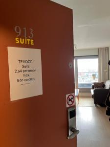 a room with a sign on a wall with a living room at Golfsuite 13 in Blankenberge