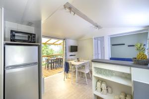 a kitchen with a refrigerator and a table at Camping El Canto la Gallina in Valdemaqueda