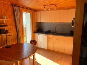 eine Küche mit einem Holztisch und einem Holzboden in der Unterkunft Chalet Florida in Bürchen