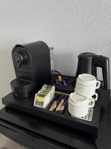 a black counter with a coffee maker and cups at Hotel Mayflower in Leiden