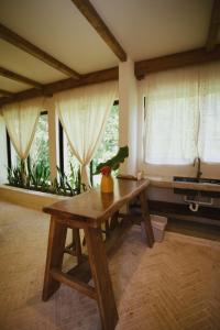 a wooden table in a room with windows at El Valle Villas in Santa Bárbara de Samaná +246 photos