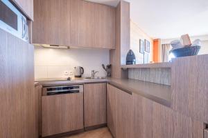 a kitchen with wooden cabinets and a sink at Résidence Pierre & Vacances Atria-Crozats in Avoriaz