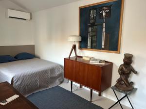 a bedroom with a bed and a dresser with a lamp at Maison Cerise in Arles +4 photos