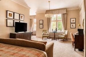 a living room with a couch and a television at Macdonald Berystede Hotel & Spa in Ascot