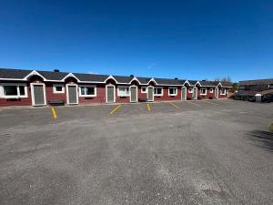 a row of red buildings in a parking lot at Motel au Fleuve d'Argent in Rivière-du-Loup