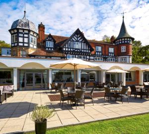 a hotel with tables and chairs in front of a building at Macdonald Berystede Hotel & Spa in Ascot