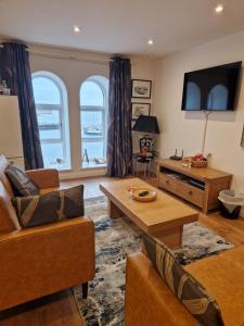 a living room with a couch and a table at 8 Mill Wharf in Berwick-Upon-Tweed