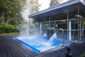a building with a swimming pool with a water fountain at Macdonald Berystede Hotel & Spa in Ascot
