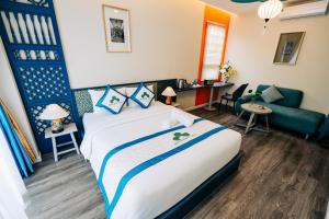 a hotel room with a bed and a couch at Indochine Casa Hotel in Ho Chi Minh City