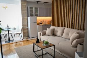 a living room with a white couch and a table at Ana Central Studio in Smederevo