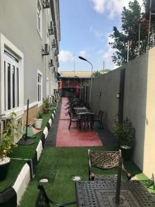a row of tables and benches in a courtyard at ADJ Royalty Hotel & Suites in Benin City