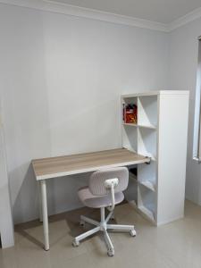 an office with a wooden desk and a chair at Homy Kwinana in Wellard